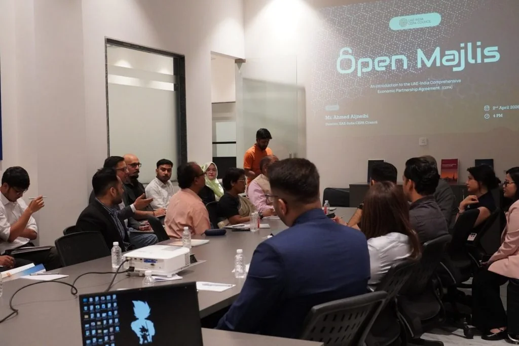 A session around a long meeting table, with the Open Majlis title slide projected on the wall.